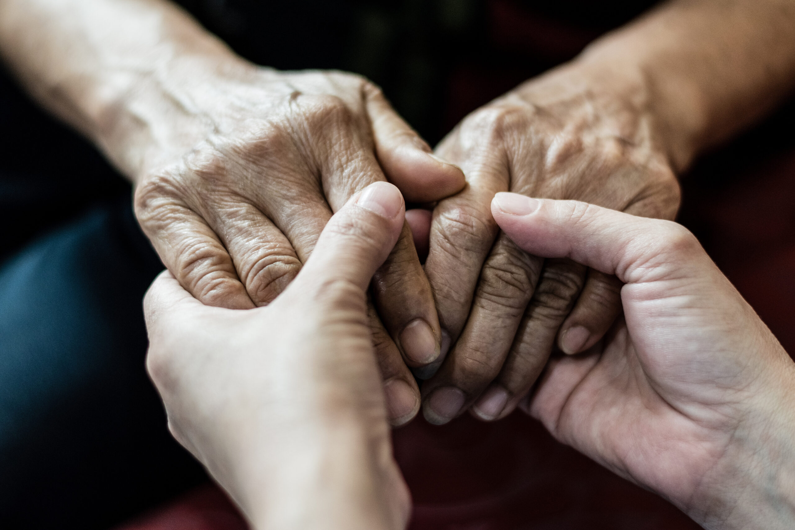 Parkinson and Alzheimer female senior elderly patient with caregiver in hospice care. Doctor hand with stethoscope check up older woman people. Old aging person seeing medical physician in hospital.